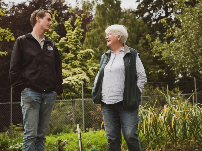 Farm To Garden General manager discussing sustainable growing practices in a field with a customer.